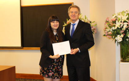 Paulina Zamora, coordinadora de Relaciones Internacionales recibe la beca a nombre de la alumna Juanita Díaz, de la carrera de Diseño Gráfico