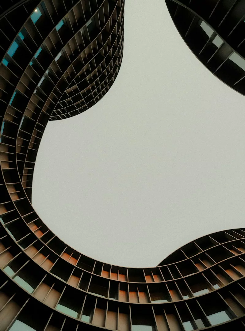 Curved modern building facades with a grid pattern framing the sky